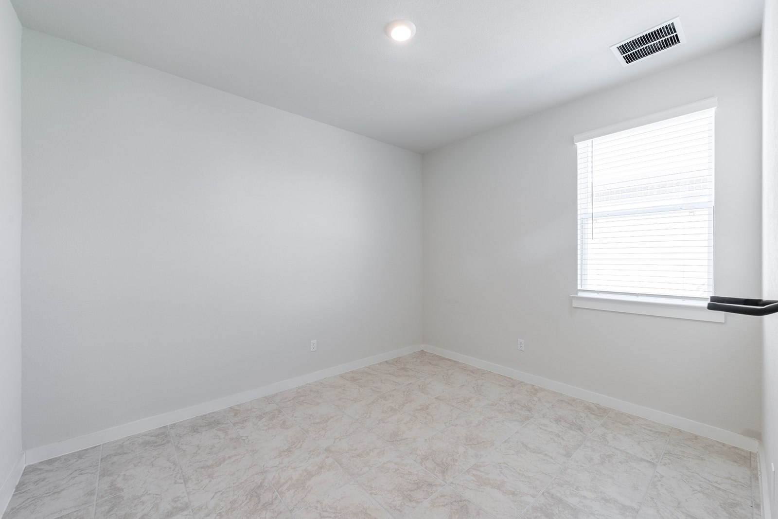 Third bedroom — bright and clean with tile floors, recessed lighting and window