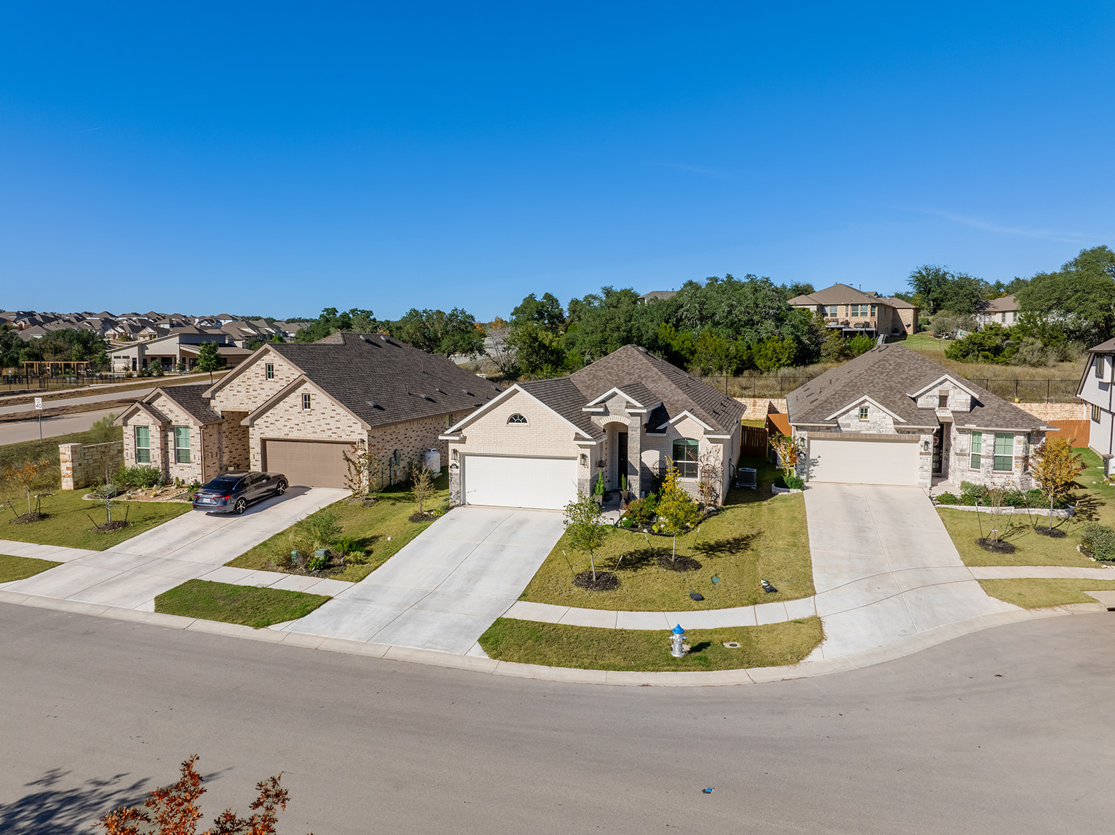 Wide street view — single-story Chesmar home in Water Oak at San Gabriel neighborhood