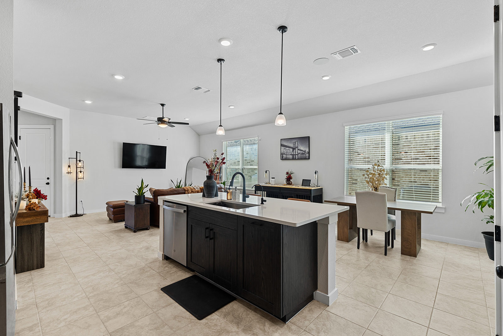 Kitchen island with dishwasher, pendant lights, dining area and living room views